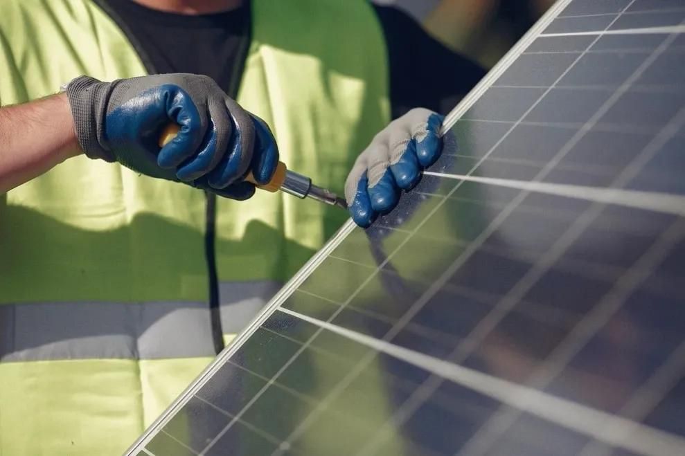 Installateur schraubt an PV-Module