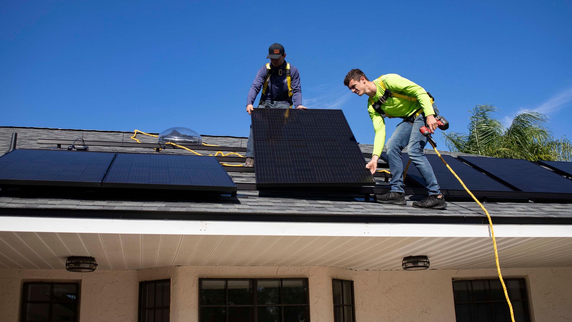 Zwei Installateure bei der Montage von Solarpanels auf einem Dach