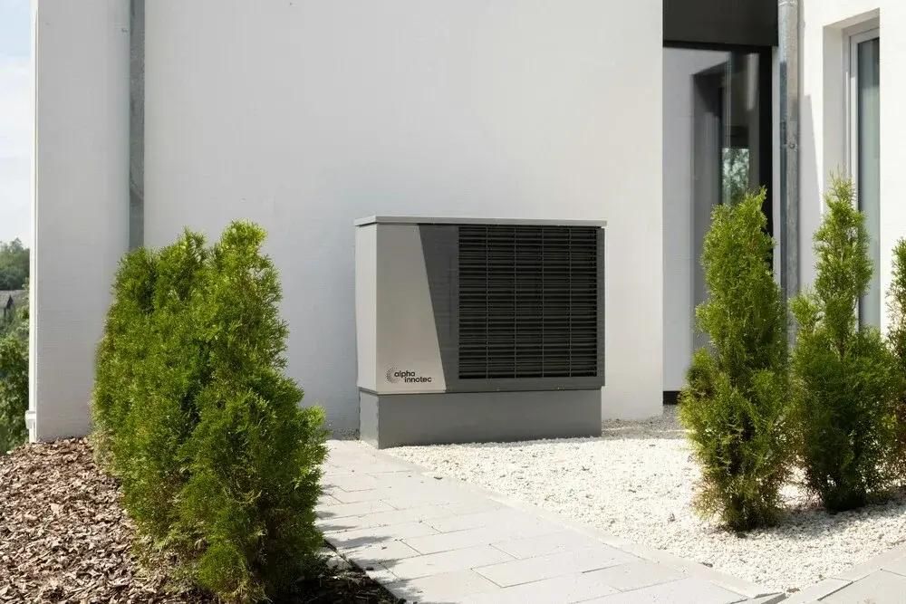 Wärmepumpe im Garten eines Privathauses