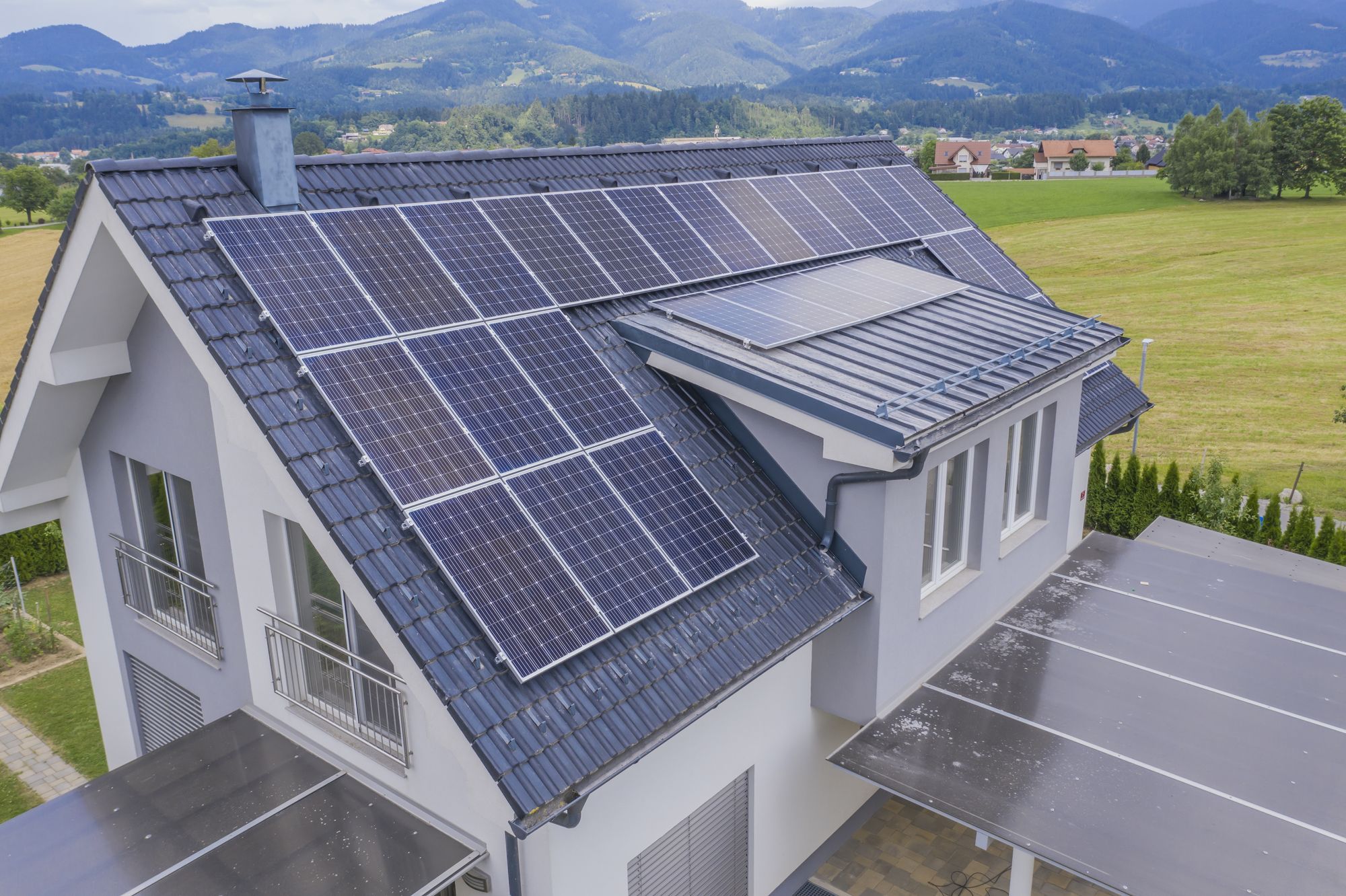 Haus mit Bergen im Hintergrund, Solaranlage auf dem Dach